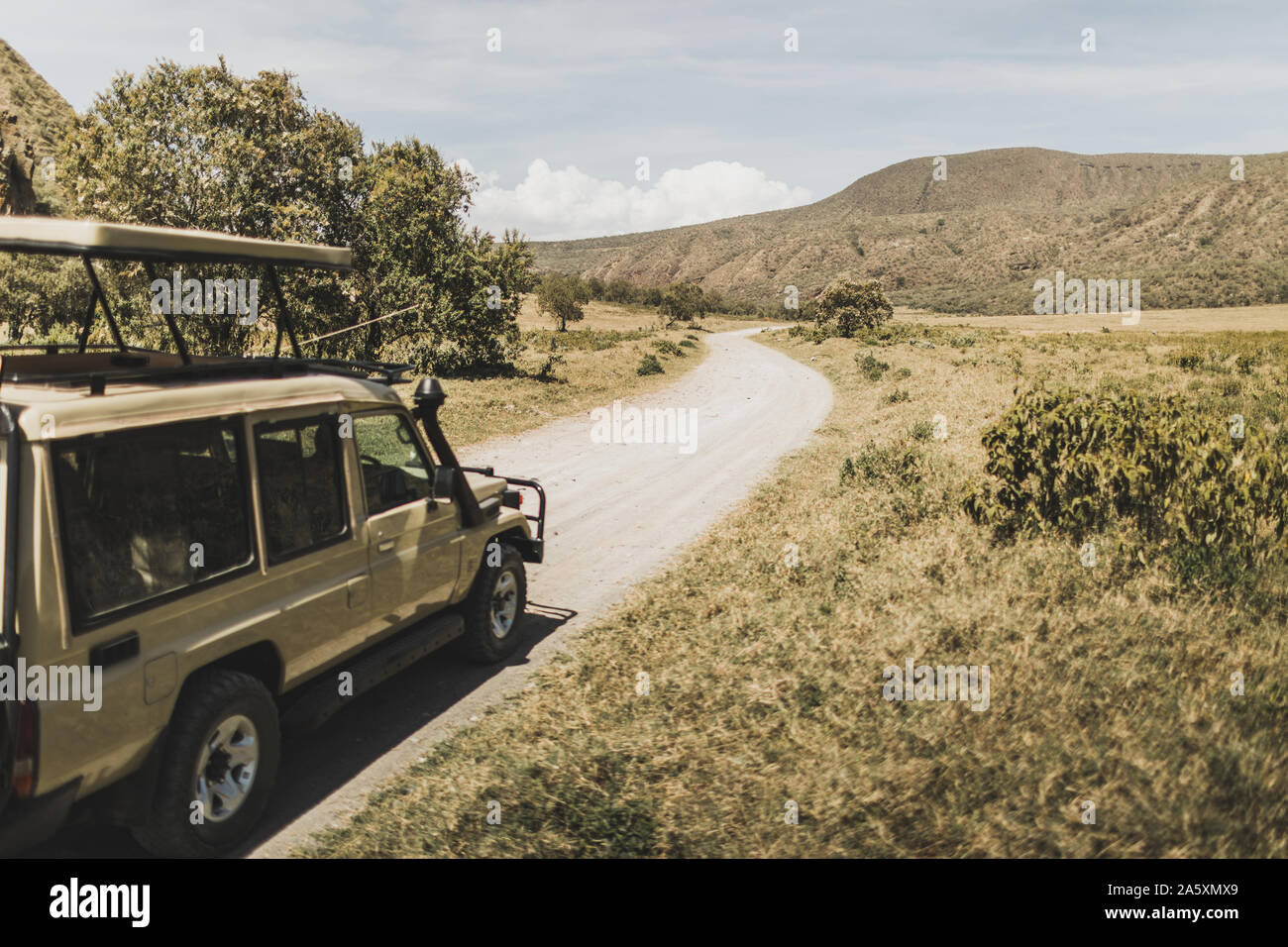 Safari in Hell's Gate national park in Kenya. Off road jeep car, savanna and mountain view. Explore wilderness of Africa. Stock Photo
