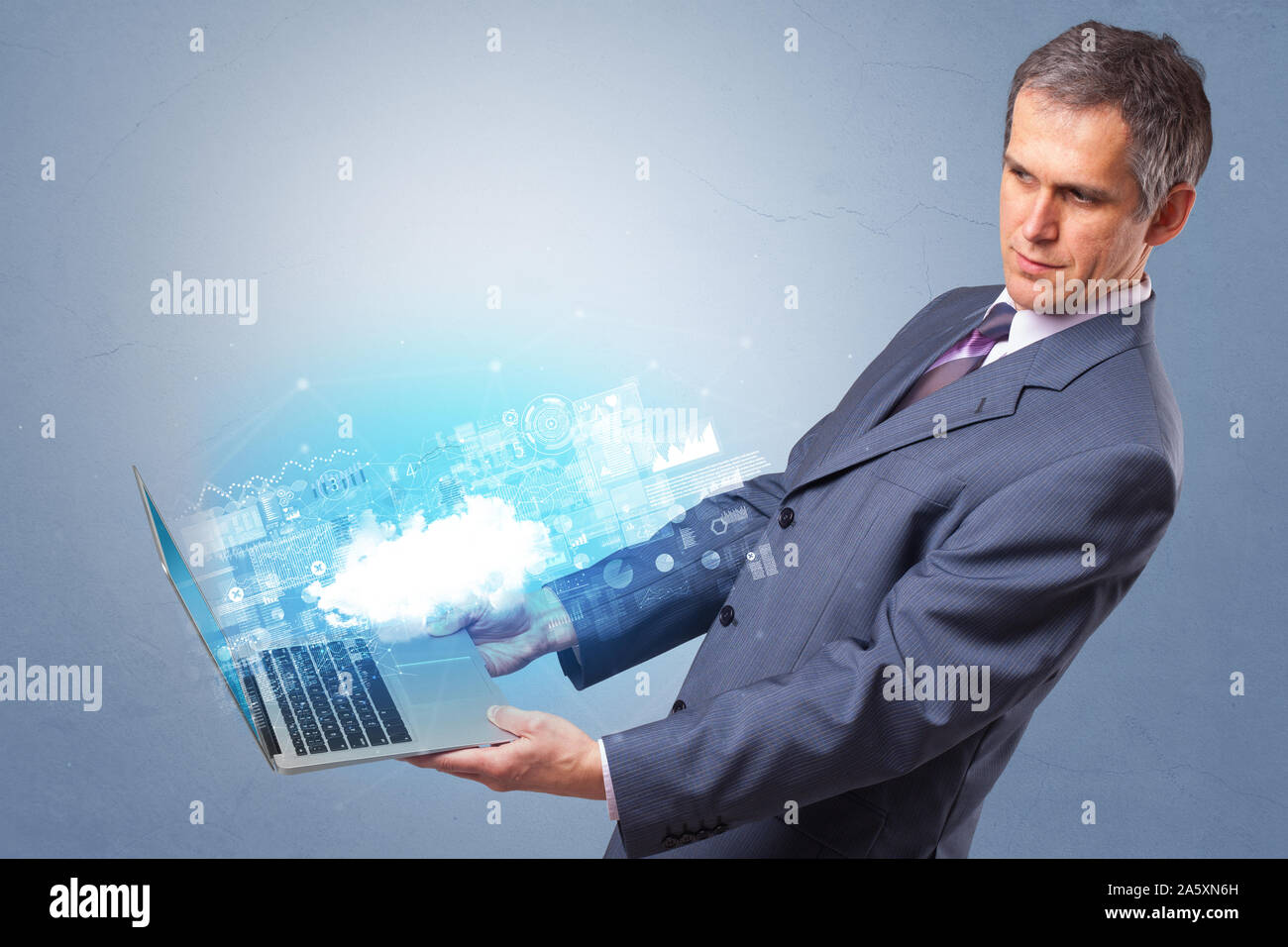 Man holding laptop projecting notifications, symbols and information based on cloud technology system Stock Photo