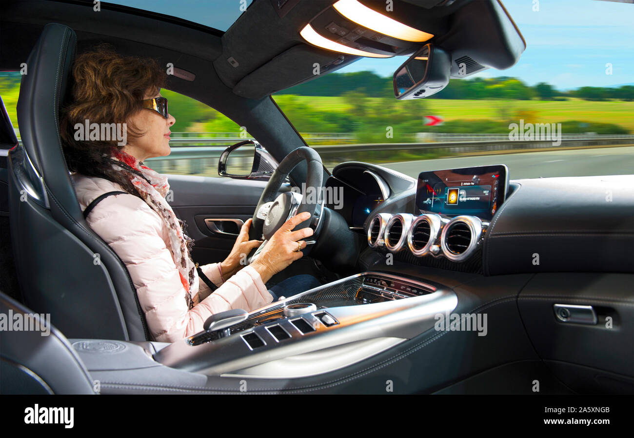adult woman driving a super modern car on the autobahn. Riding is a pleasure Stock Photo