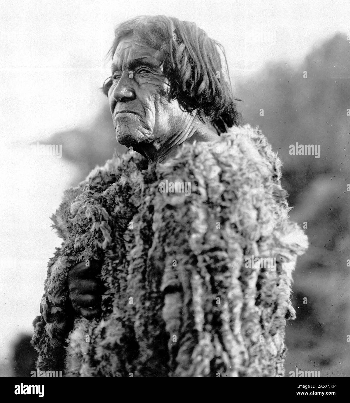 Edward S. Curits Native American Indians - Mohave man, half-length portrait, facing left wearing 'primitive' robe of rabbit skin ca. 1907 Stock Photo