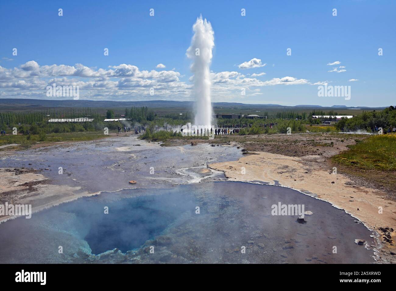 Hot water pool and erupting Strokkur Geysir, hot water valley Haukadalur, Golden Circle, Iceland Stock Photo