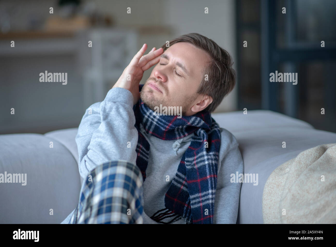 Dark-haired young man suffering from strong headache Stock Photo