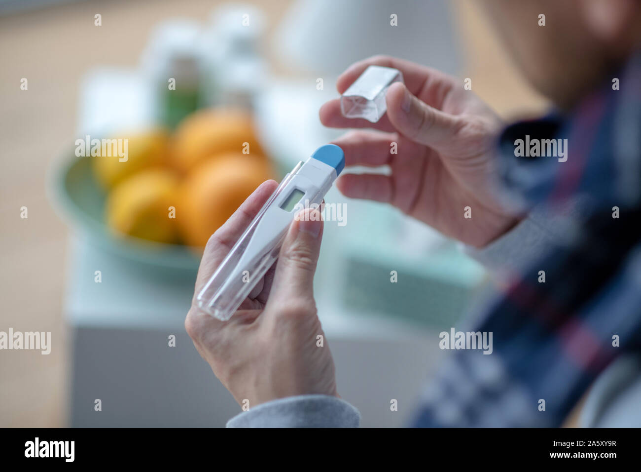 Man using thermometer while having high fever Stock Photo Alamy