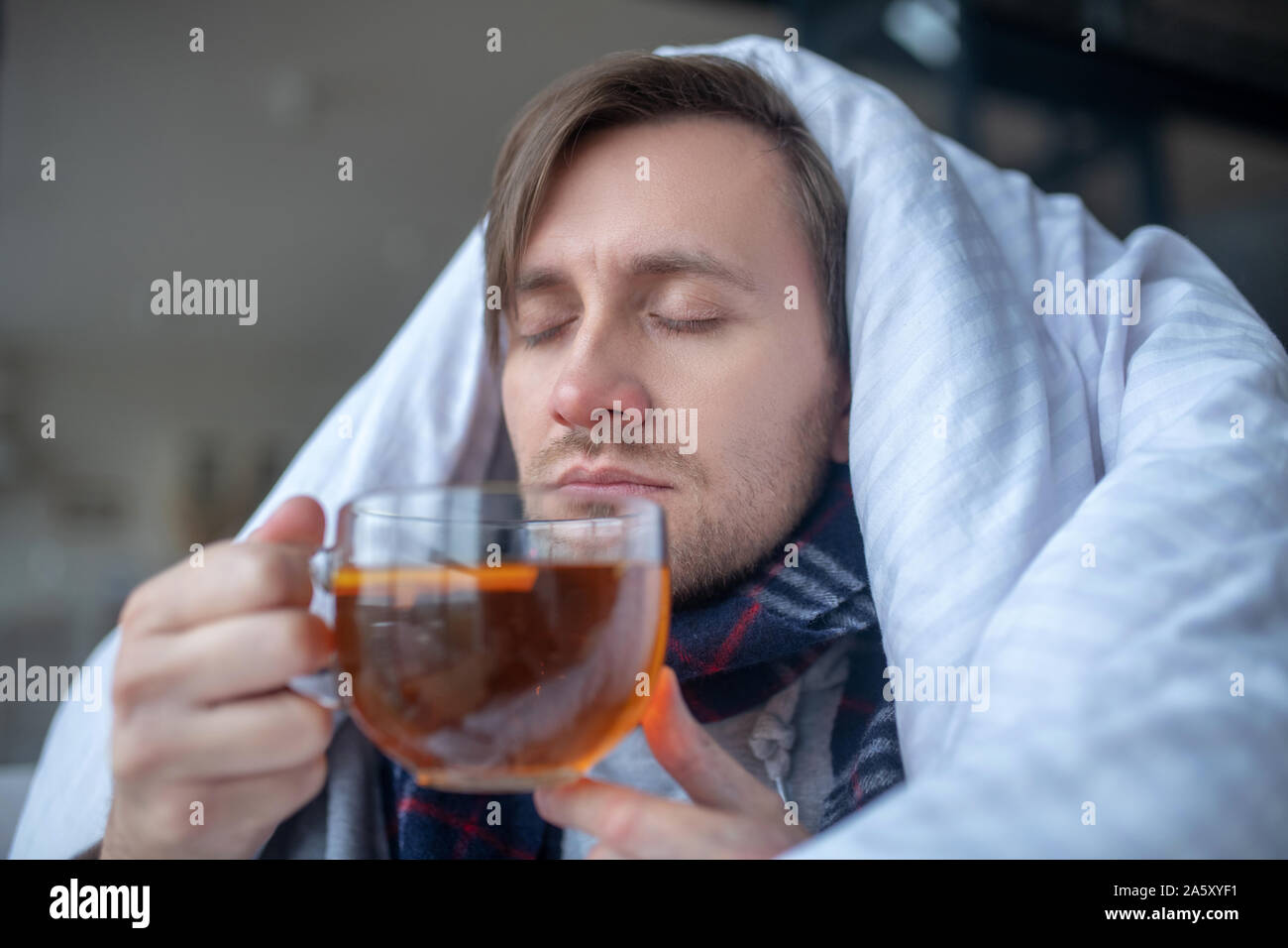 Sick man drinking hot black tea while having flu Stock Photo Alamy