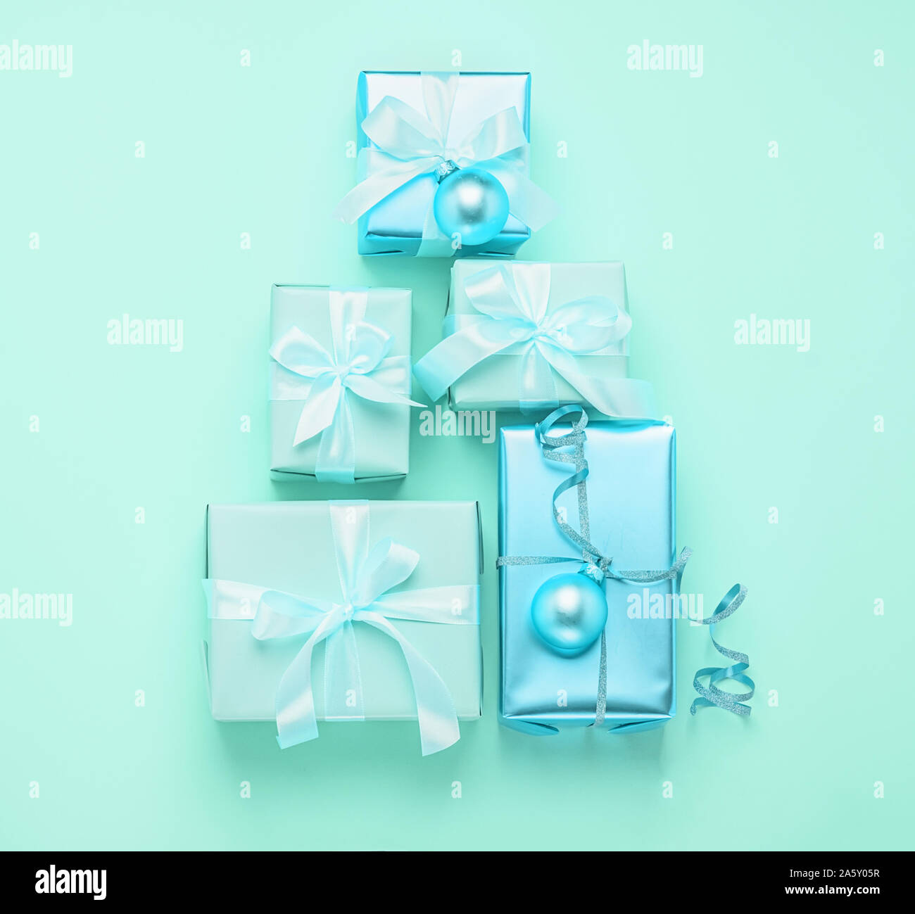 Christmas creative tree of holiday gift boxes on a pastel mint neon ...
