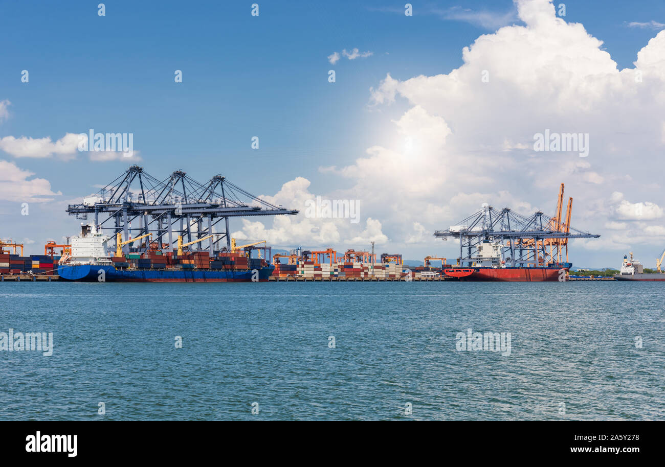 Cranes loading containers on large port cargo transport ship at day ...
