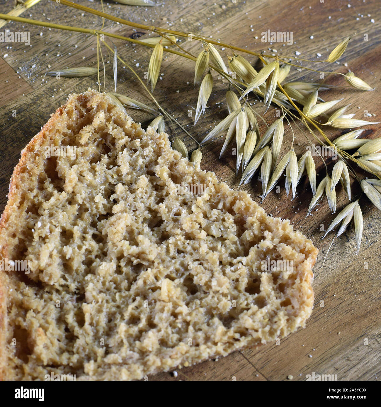 Top view of oat bread. Oat ears of grain on brown wooden table. Close up square shape image. Stock Photo