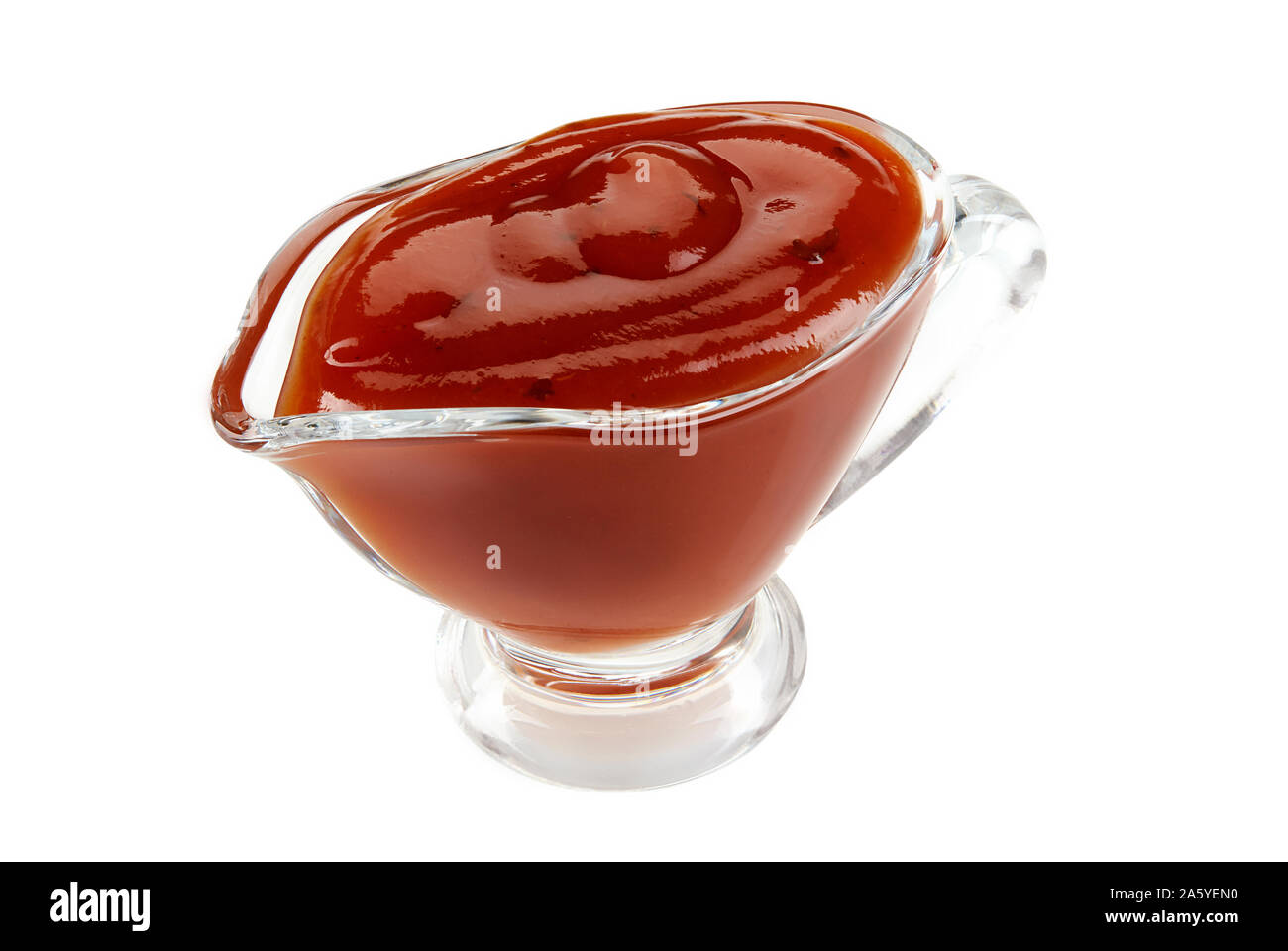 Tasty ketchup sauce in a glass gravy boat isolated on white background