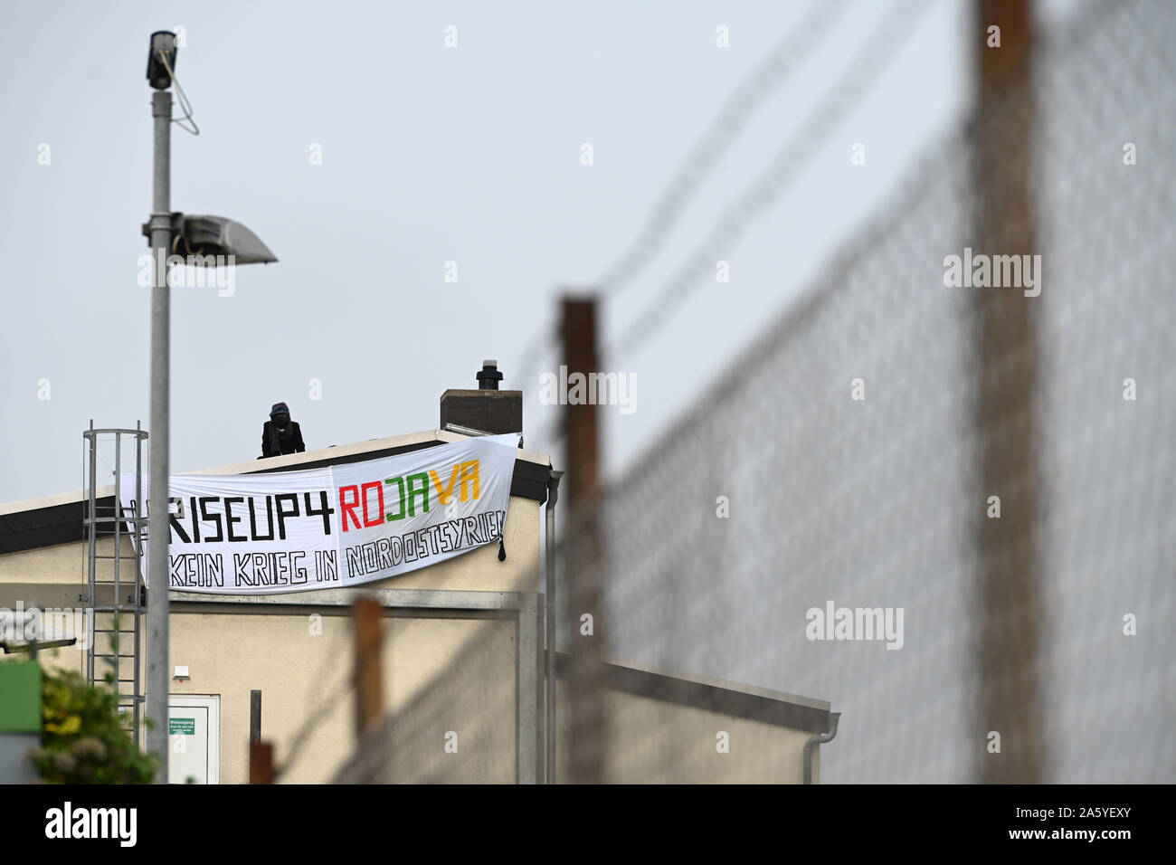 Kassel, Germany. 23rd Oct, 2019. Proxy activists have occupied the roof of  the arms company Krauss-Maffei Wegmann and hold a banner "RiseUp4Rojava No  War in Northeast Syria" to protest against the Turkish