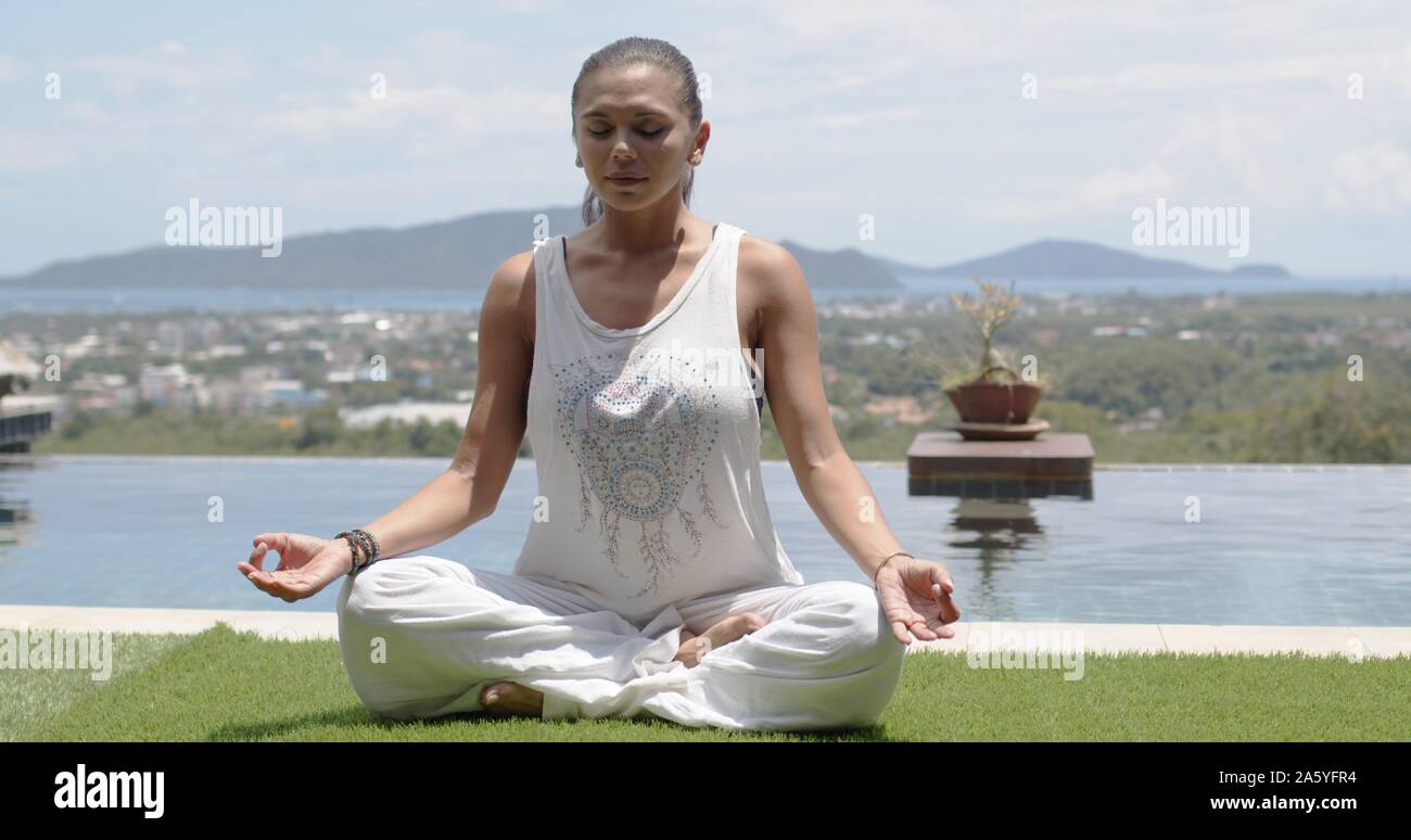 Lady practicing yoga in lotus pose against ocean coast Stock Photo - Alamy