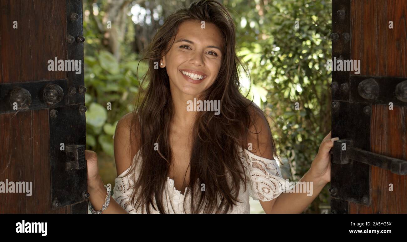 Joyful young woman standing in doorway Stock Photo