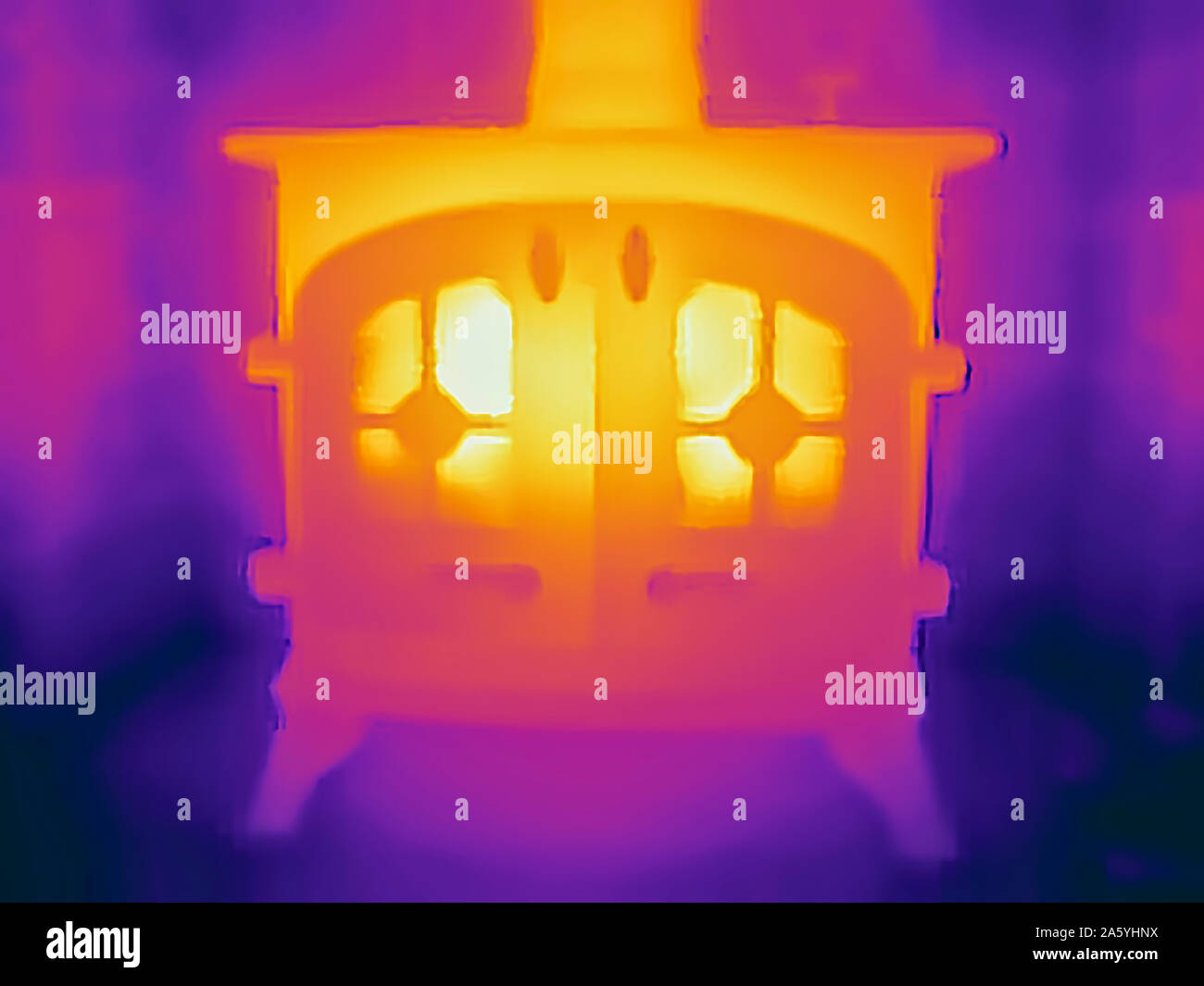 Thermal Image camera picture of a hot log-burning stove warming a farm house on a cold day, maybe under-threat from Michael Gove's Clean Air Strategy, Wirksworth, Derbyshire Stock Photo