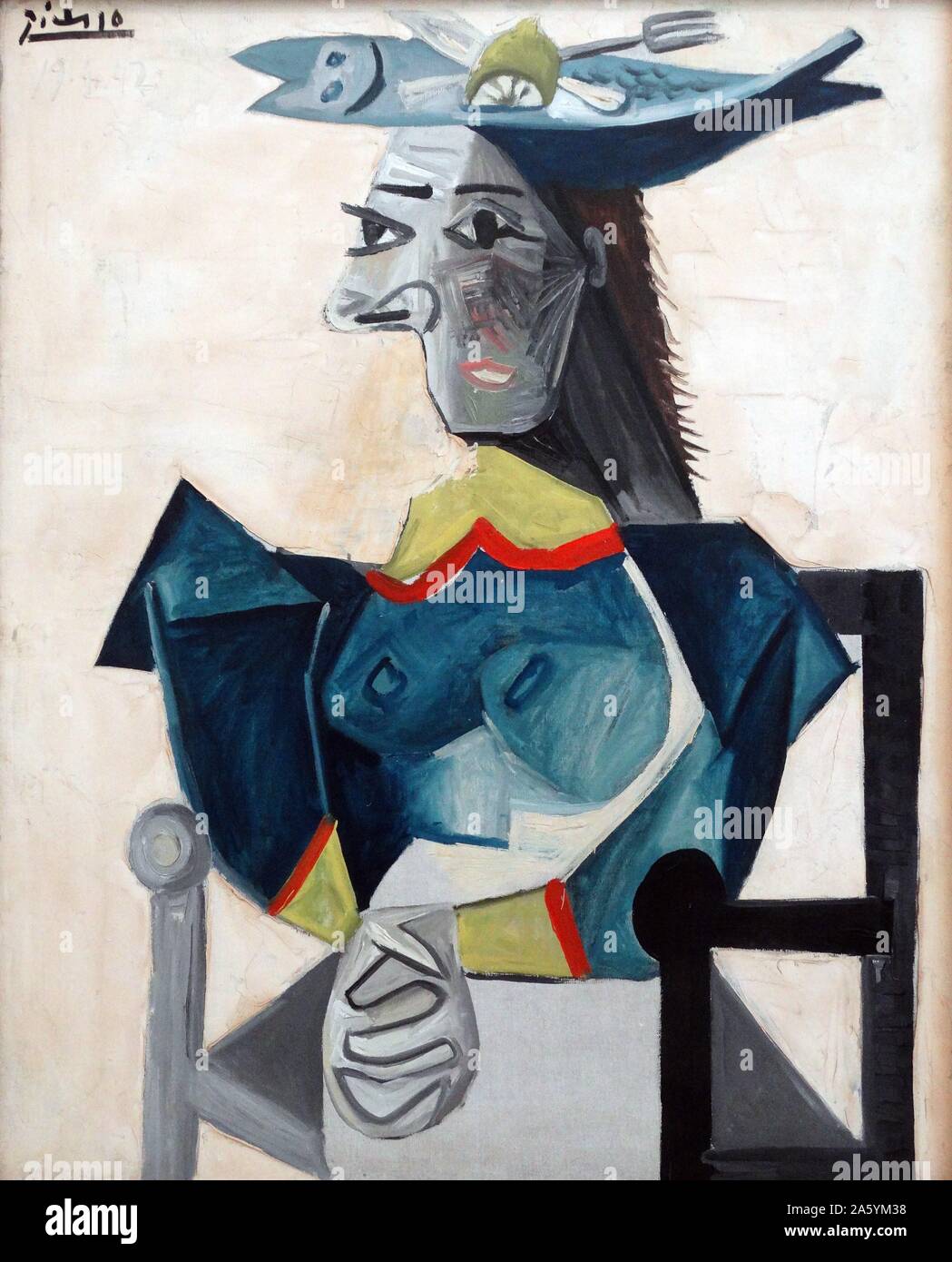 Seated Woman with Fish Hat (print on canvas) by Pablo Picasso (1881-1973) a Spanish painter, sculptor, printmaker, ceramicist, stage designer, poet and playwright who spent most of his adult life in France. Stock Photo