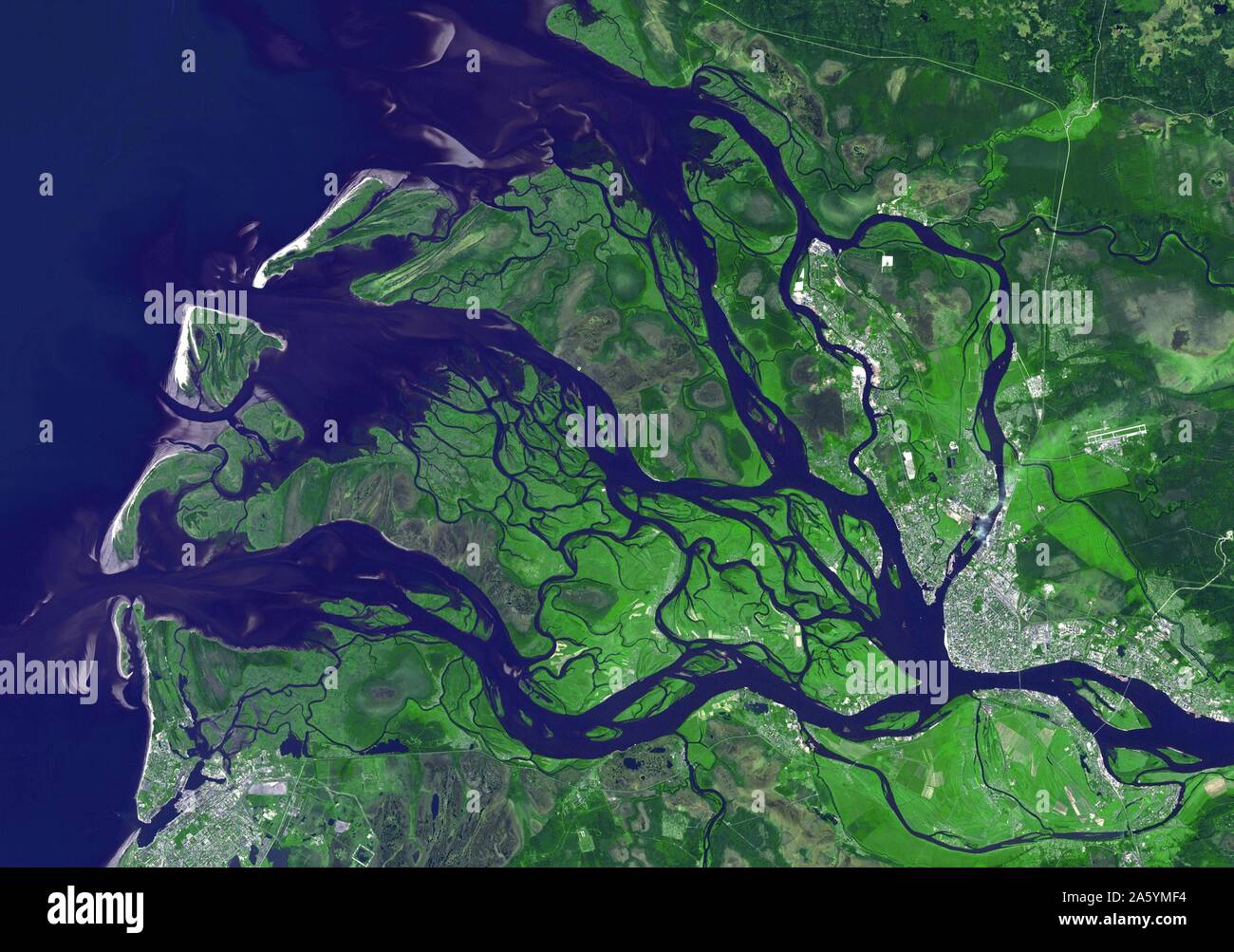 Arkhangelsk (or Archangel in English) is a city and the administrative capital of Archangelsk Oblast, Russia. It is situated on both banks of the Dvina River near where it flows into the White Sea. July 14, 2010. Satellite image. Stock Photo