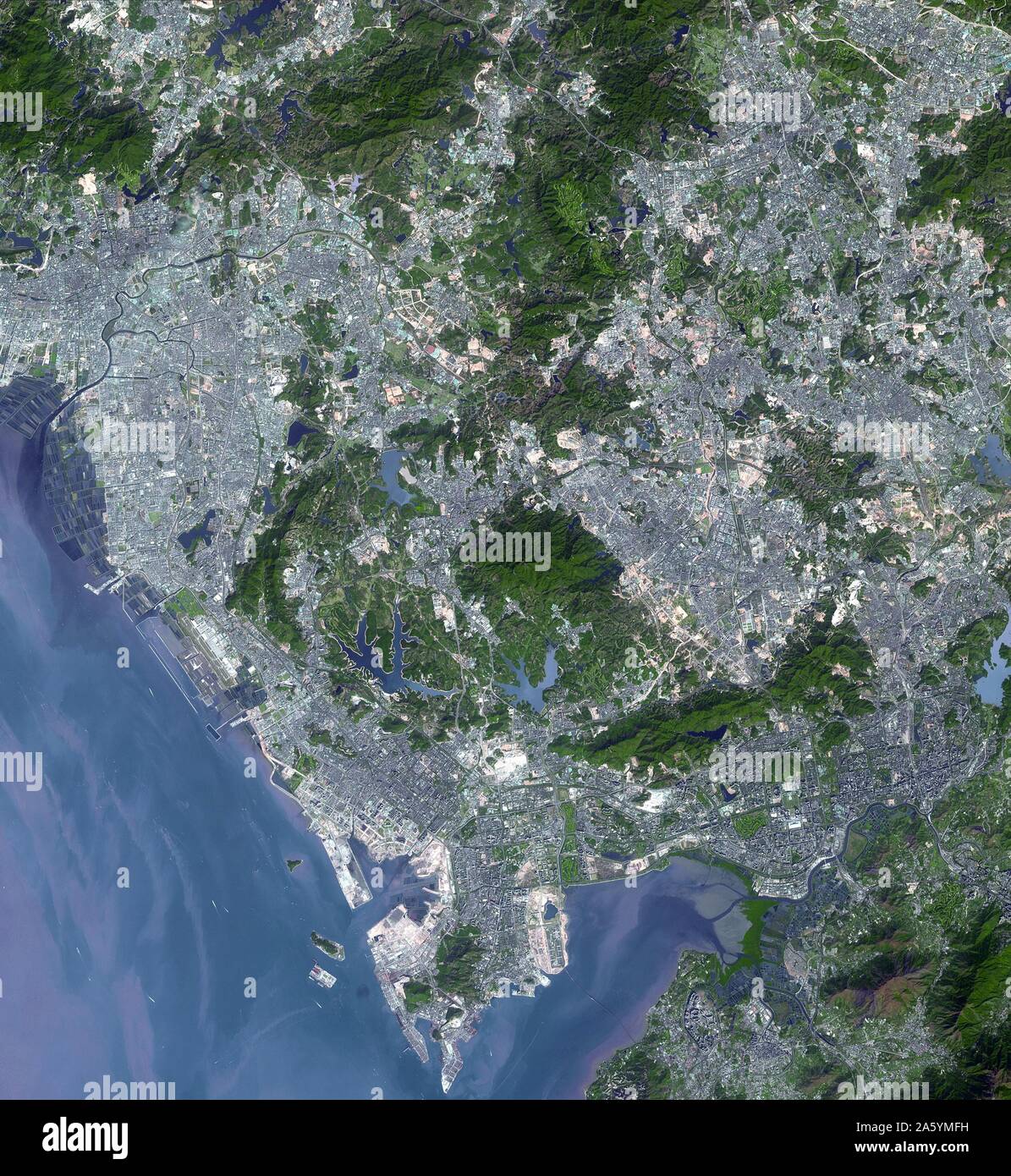 Shenzhen is a city of sub-provincial administrative status in southern China's Guangdong province, immediately north of Hong Kong, and located in the Pearl River Delta. Evidence of urbanization is evident in these two images. November 15, 1999 and January 1, 2008. Satellite image. Stock Photo