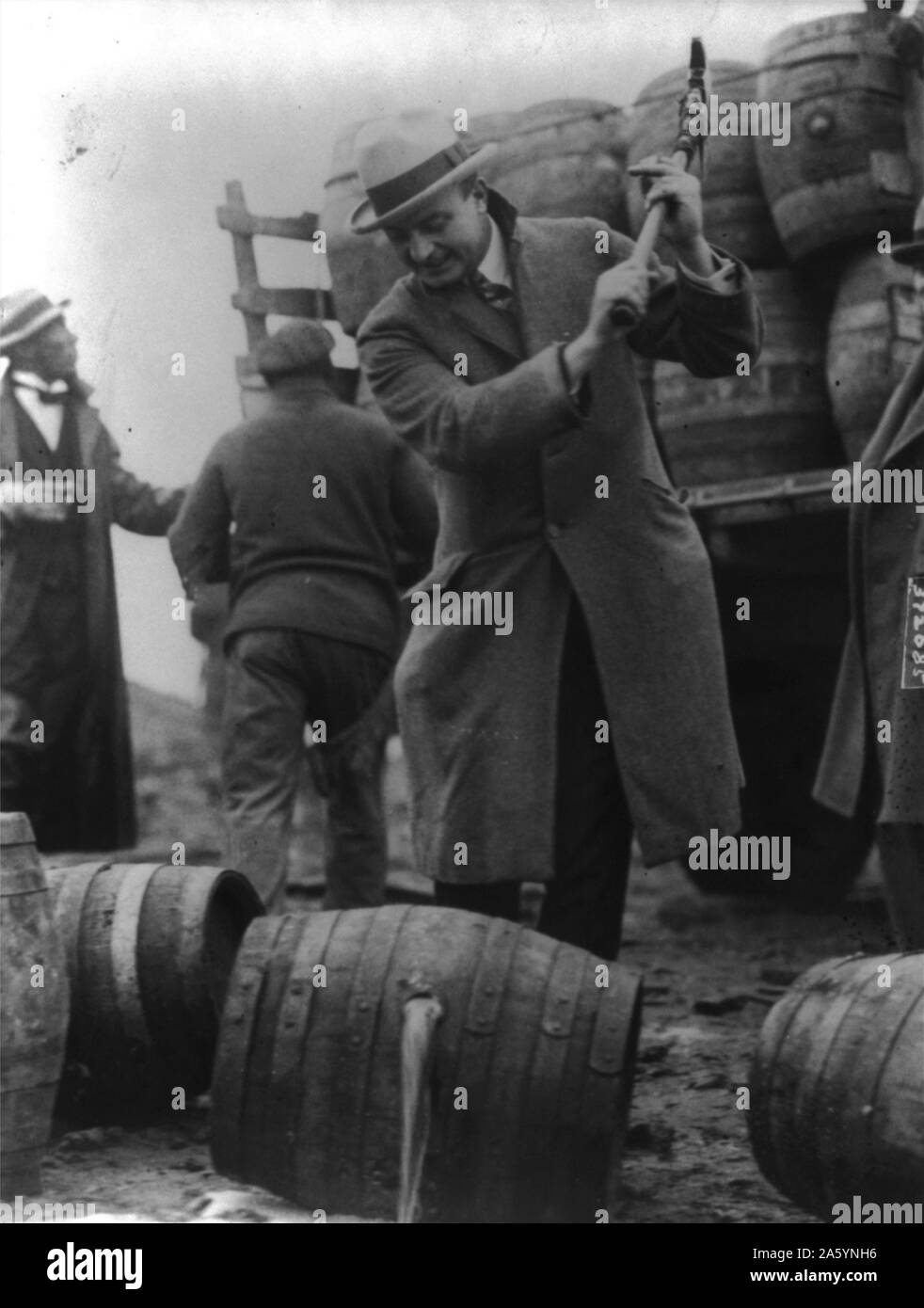 FBI Officer breaks a confiscated barrel of beer as part of the prohibition campaign against alcohol in the USA in the 1920's. Date 1924. Stock Photo