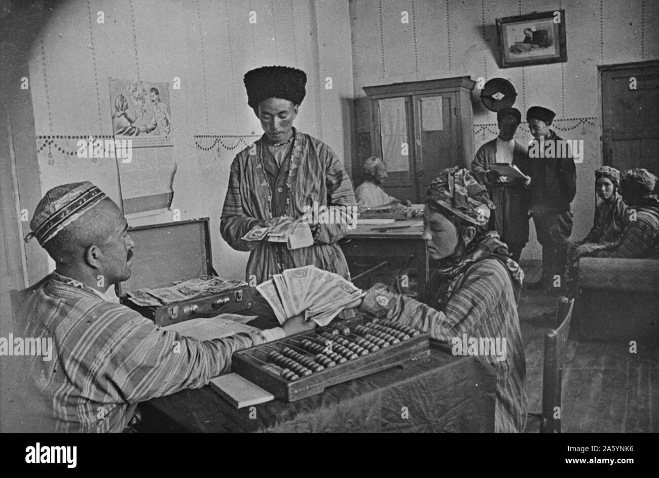 Turkmenian collective farmers receiving part of their yearly income from the profits of the farm in the farm administration office in the USSR (Union of Soviet Socialist Republics). between 1930 and 1940 Stock Photo