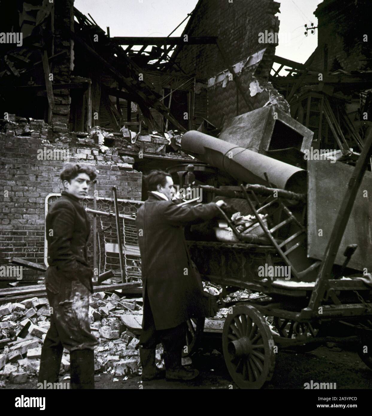 Photograph of two men loading their possessions after the Battersea Bombing Incident amongst ruins. Dated 1945 Stock Photo