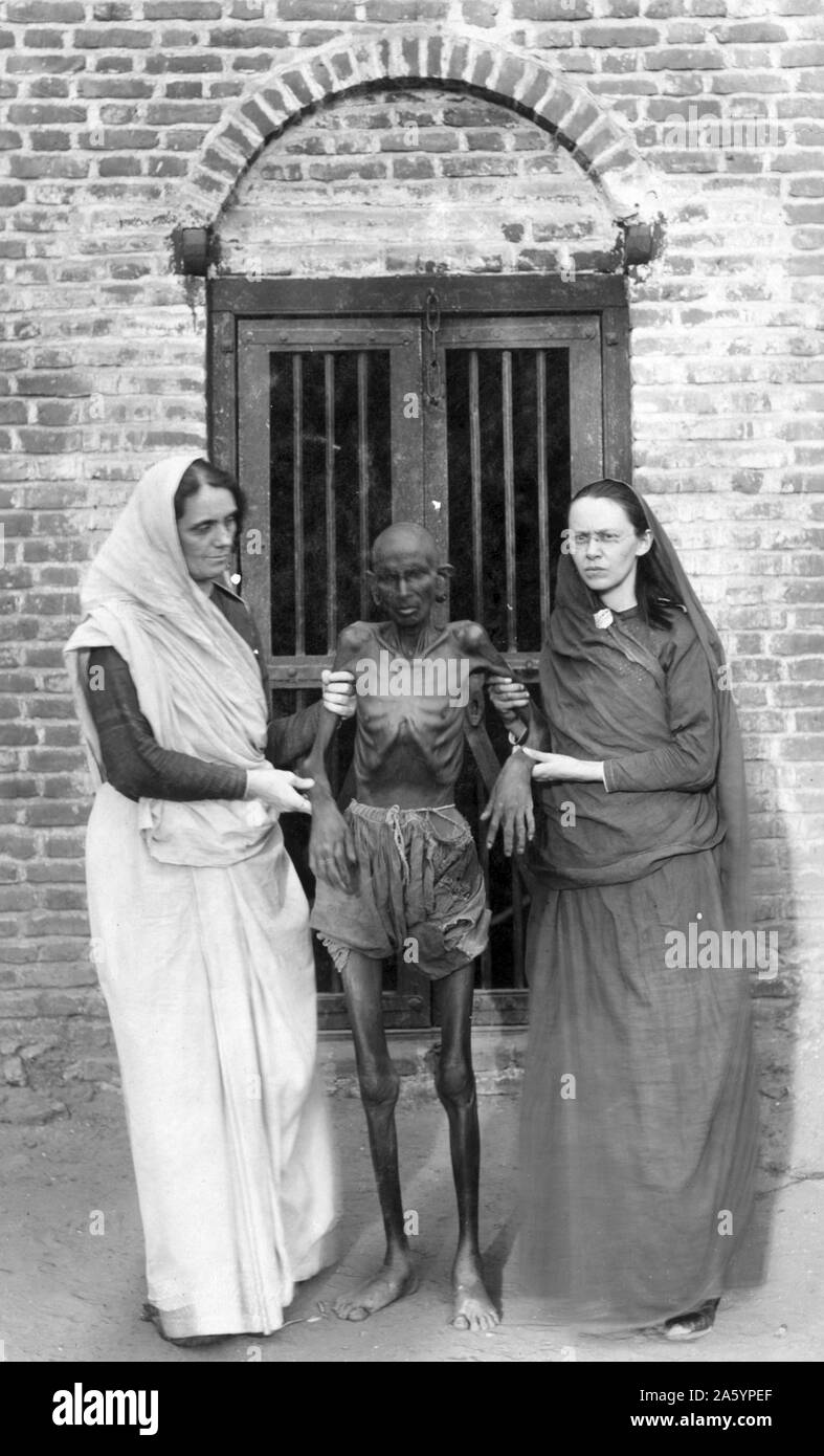 Photographic print of an emaciated famine victim standing in between Miss Neil and an unidentified woman. Dated 1910 Stock Photo