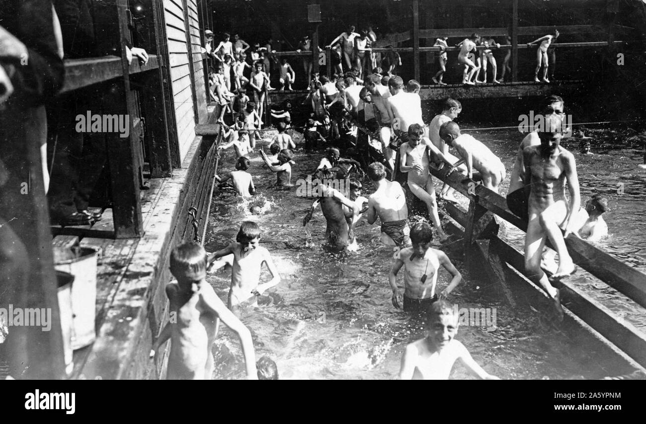 City children swimming (most without suits) in public pool at the