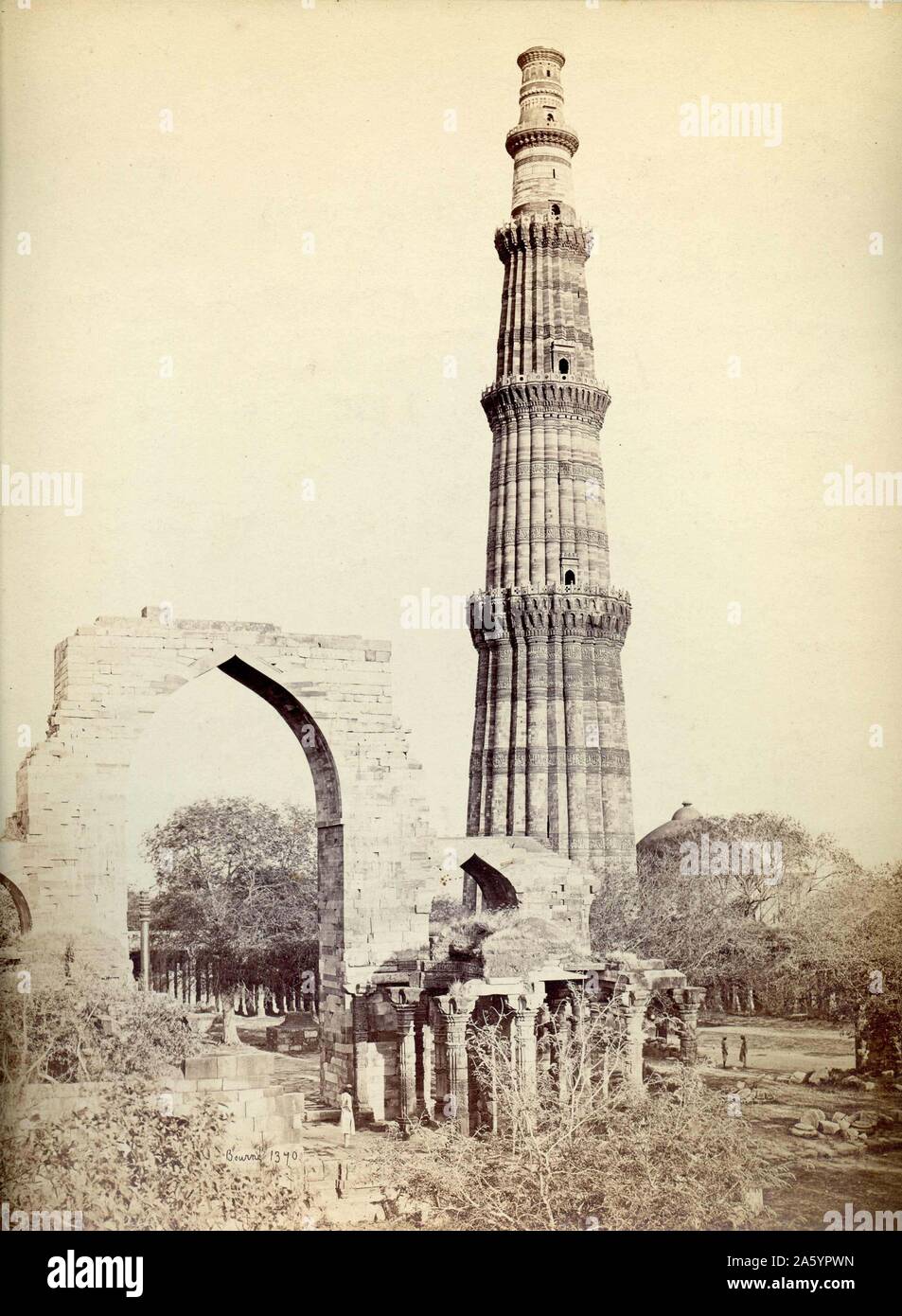 Qutb Minar in Delhi by Samuel Bourne (1834-1912). This fluted, red sandstone structure is the world's tallest brick minaret and was erected between 1193 and 1368. Stock Photo