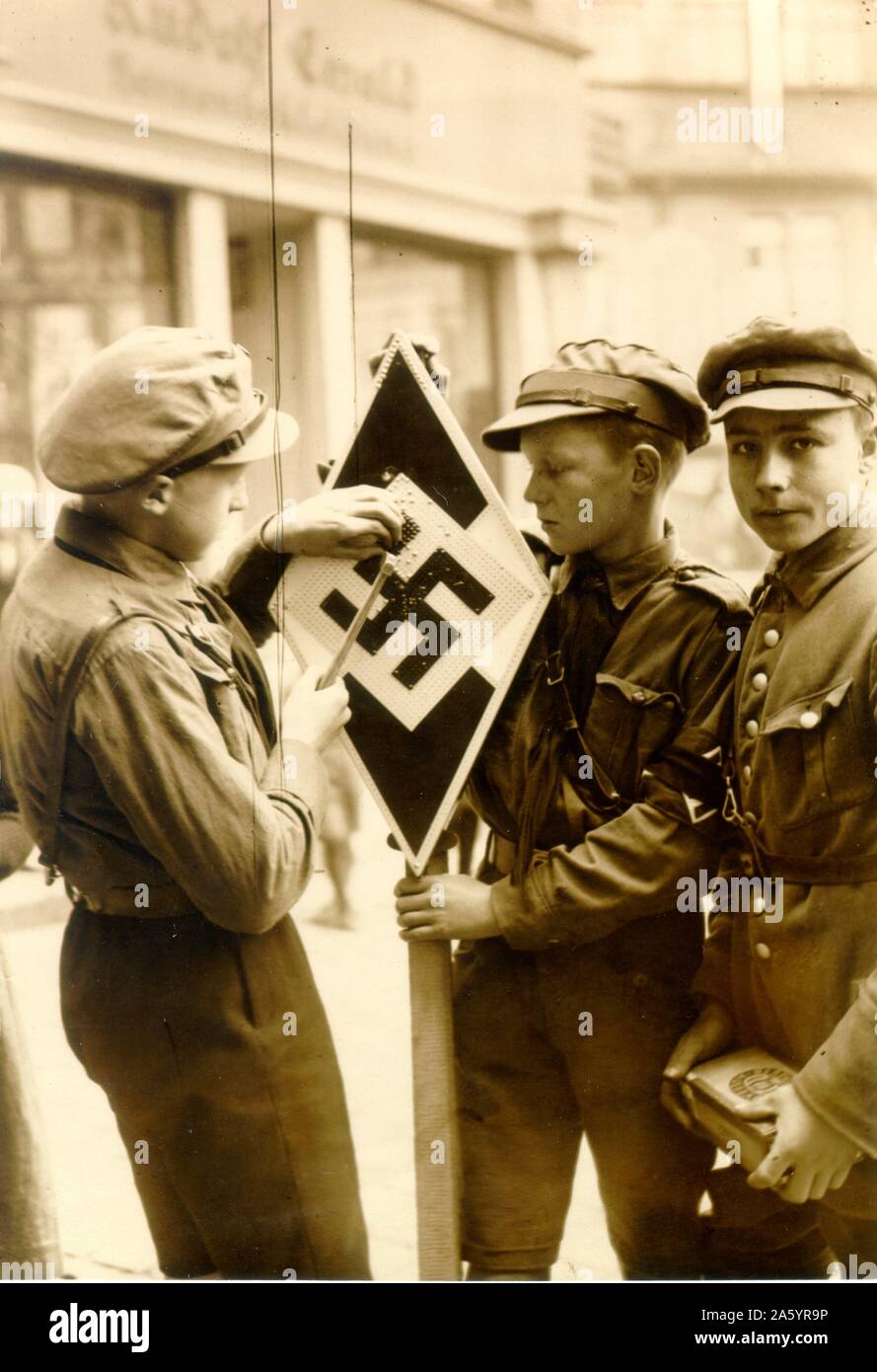 Three boys in the Hitler Youth, 1938. The Hitler Youth was the youth organisation of the Nazi Party in Germany. Its origins dated back to 1922. From 1933 until 1945, it was the sole official youth organization in Germany and was partially a paramilitary organisation. Stock Photo