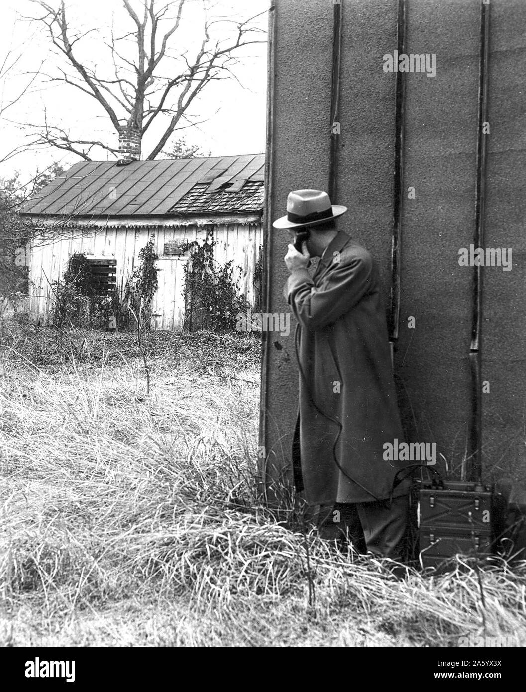 1930's FBI (federal Beureau of Investigation) officer (Agent), uses a portable phone during an operation Stock Photo