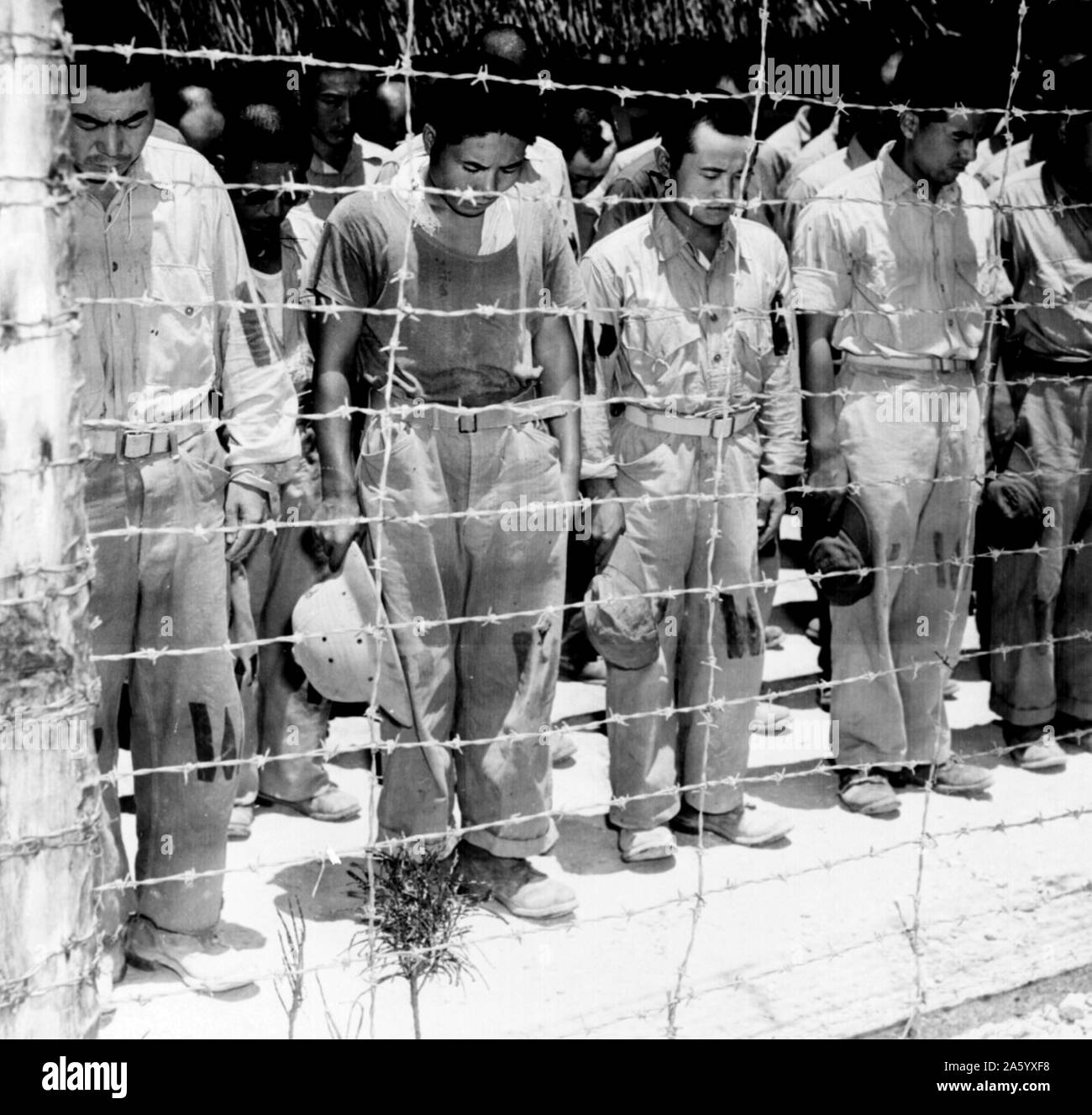 Photograph of captured Japanese guards behind barbed wire. Dated 1944 Stock Photo