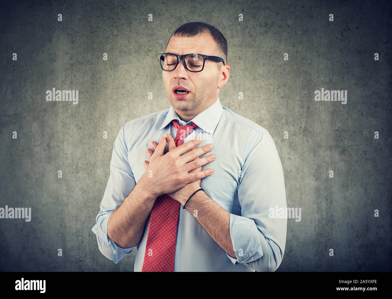 Young business man having asthma attack or chest pain Stock Photo
