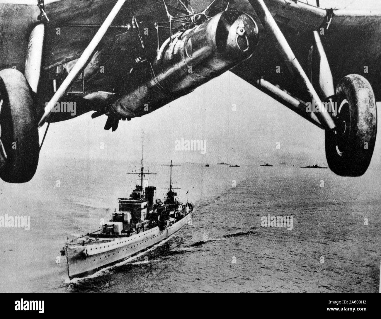 Aircraft flies above a battle cruiser of the British Royal Navy 1930's Stock Photo