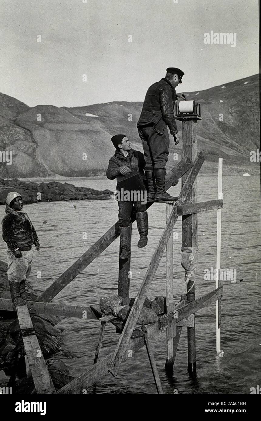 Checking tide gauge. C&GS officer accompanying MacMillan Arctic Expedition 1936 Stock Photo