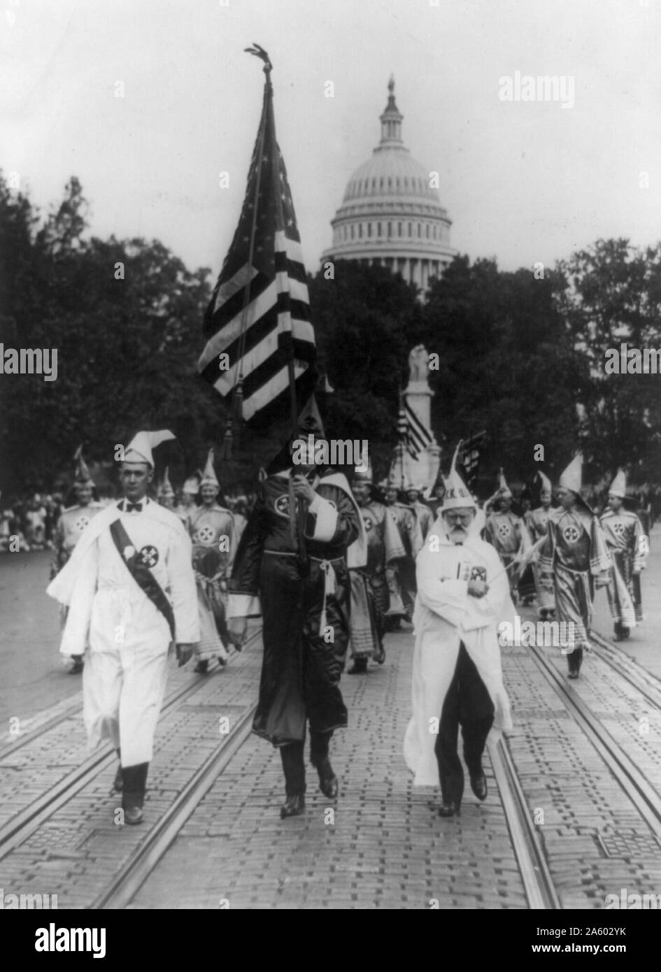 Photographic print shows a group parading on the street in front of the dome of the U.S. Capitol. In the background, leading the Kul Klux Klan parade which was held in Washington D.C.;on the right, is Mr J.M. Fraser from Houston, Texas. Stock Photo