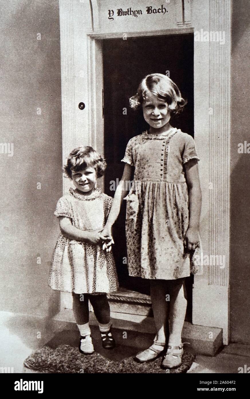 Photograph of Princess Elizabeth (1926-) and Princess Margaret (1930-2002) outside of The Little House at Royal Lodge which was a birthday gift for Elizabeth by the people of Wales. Dated 20th Century Stock Photo