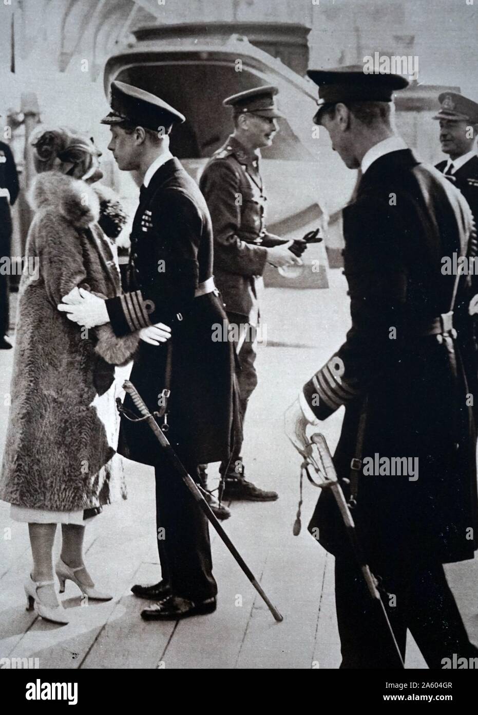 Photograph of Edward, Prince of Wales (1894-1972), kissing his sister-in-law goodbye, before leaving to visit Australasia. Also pictured is Prince Albert Frederick Arthur George (1895-1952) and Prince Henry, Duke of Gloucester (1900-1974) to bid him farewell. Dated 20th Century Stock Photo