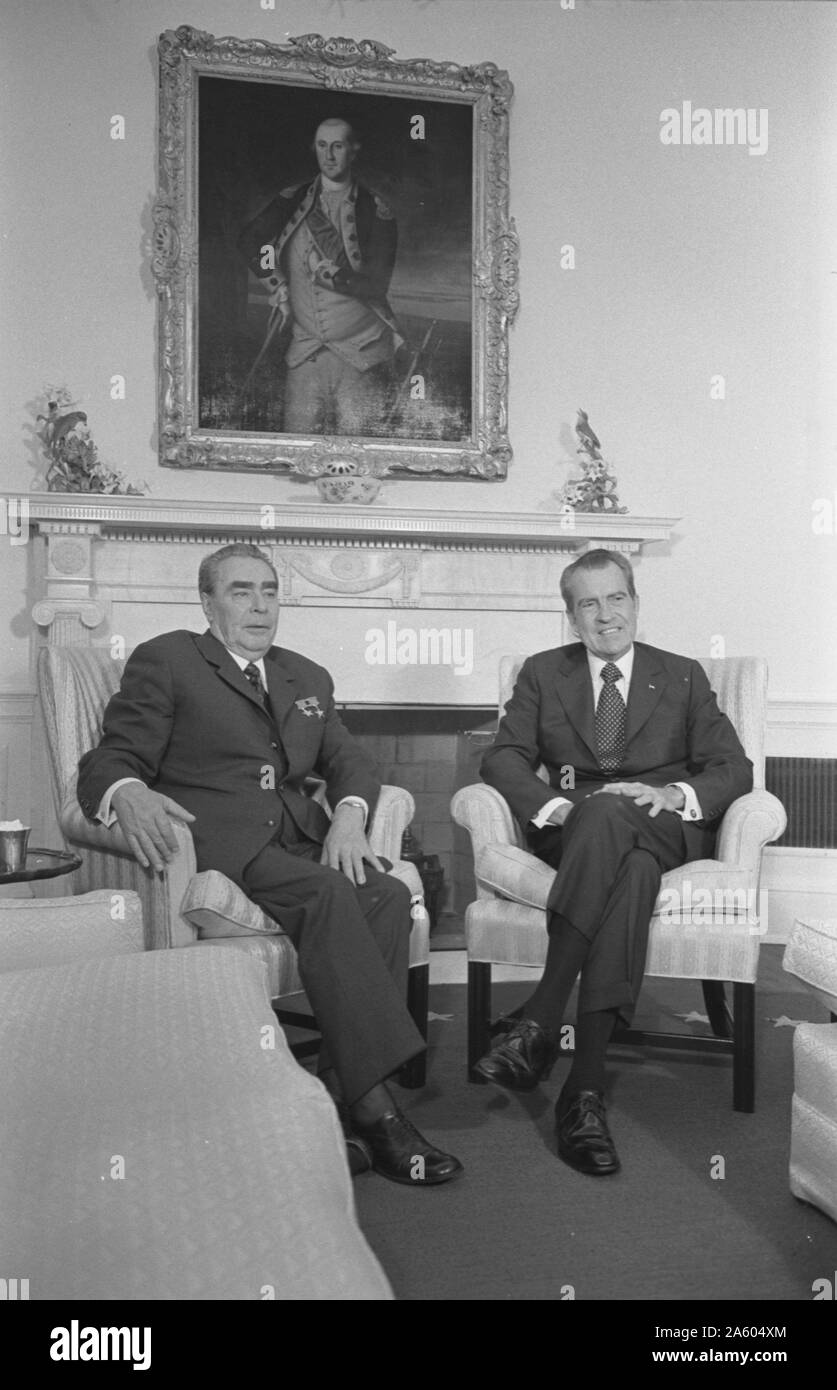 President Richard Nixon and Soviet leader Leonid Brezhnev seated in the White House; portrait of George Washington in the background Stock Photo