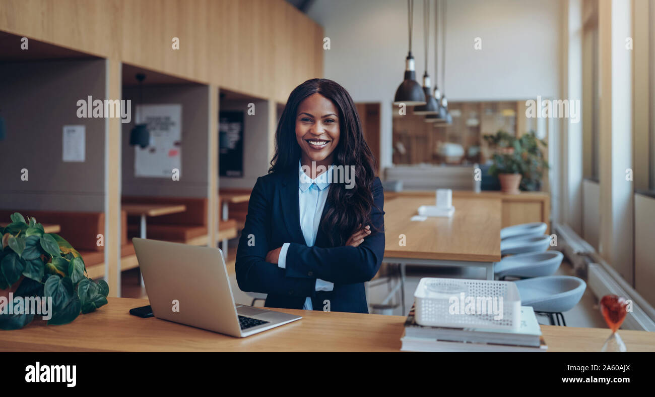 Smiling young African American businesswoman standing confidently with ...