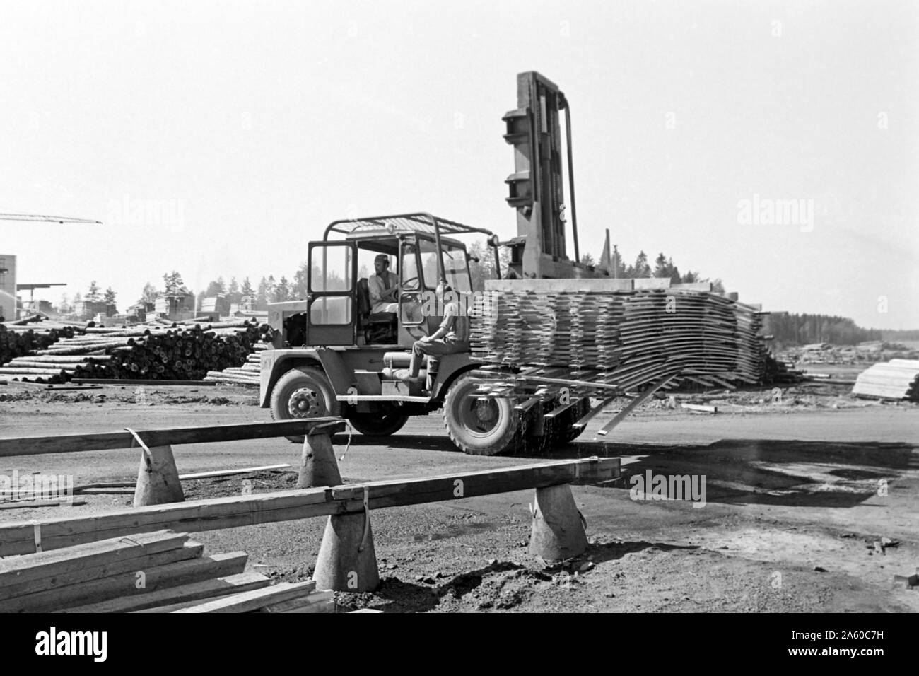 Gabelstapler mit Holzstapel auf Sammelplatz, Bollnäs, Schweden, 1969. Forklift truck with woodpile at assembly point, Bollnäs, Sweden, 1969. Stock Photo