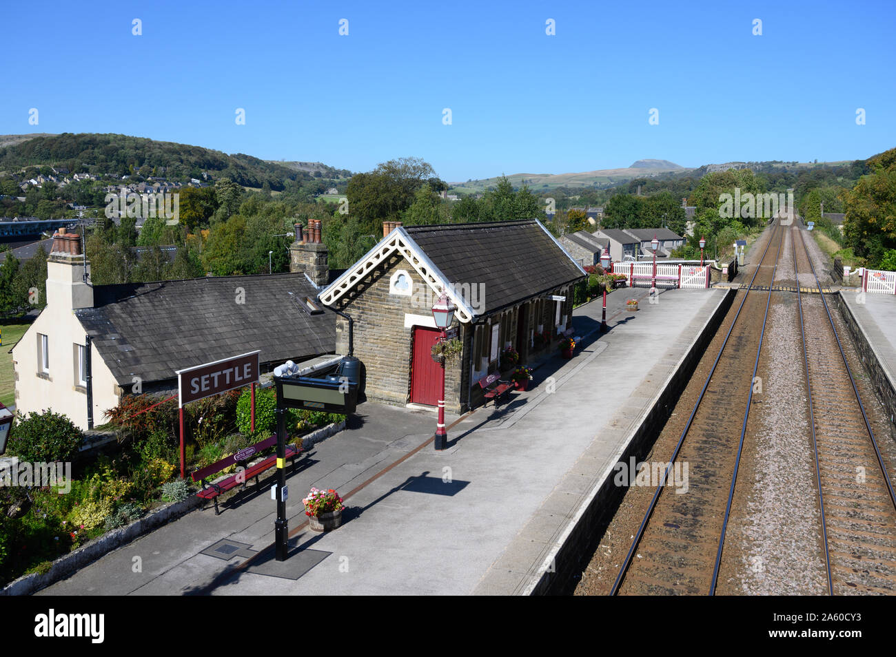 Settle Railway Station, North Yorkshire, on the famous Settle to Carlisle line with Pen-y-Ghent Fell in the distance. Stock Photo