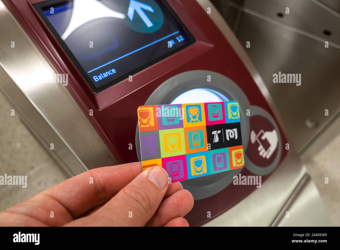 The travel card used to pay for fares on the Doha Metro in Qatar, is presented over an NFC reader at the gates. Remaining balance shown on screen Stock Photo