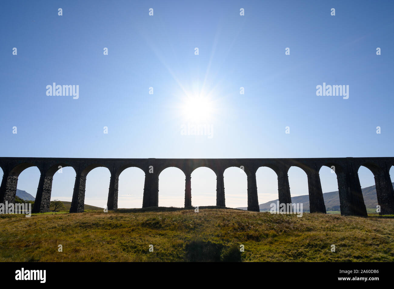 A summer sun in a blue sky over Ribblehead Viaduct on the Settle to Carlisle Railway Line, North Yorkshire. Stock Photo