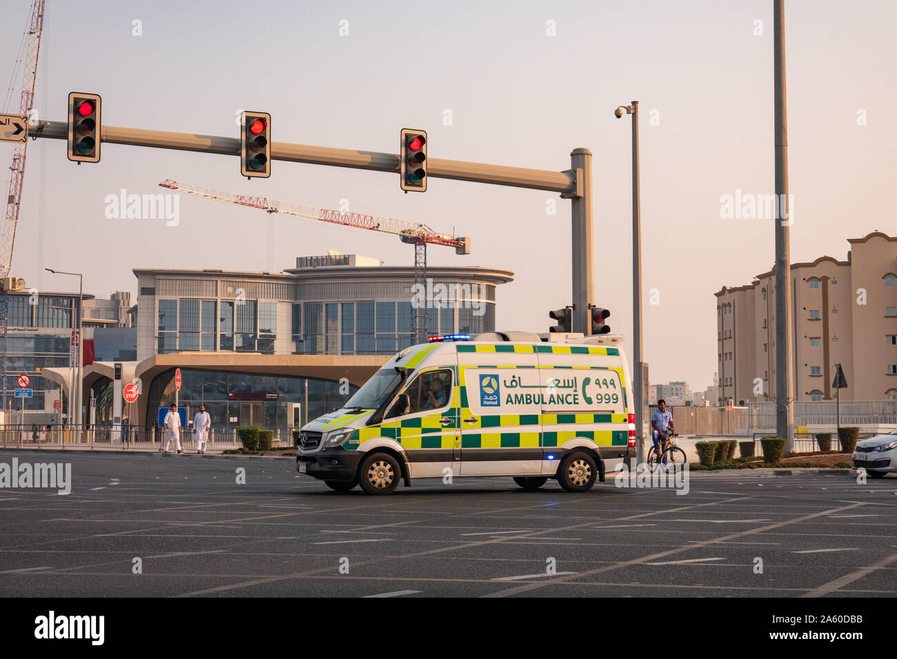 A first-response ambulance vehicle makes its way across a traffic intersection en route to an emergency in Doha, Qatar Stock Photo