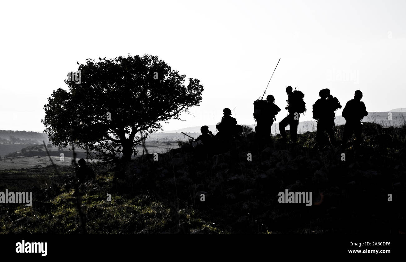 Six army soldiers patrolling during sunset Stock Photo
