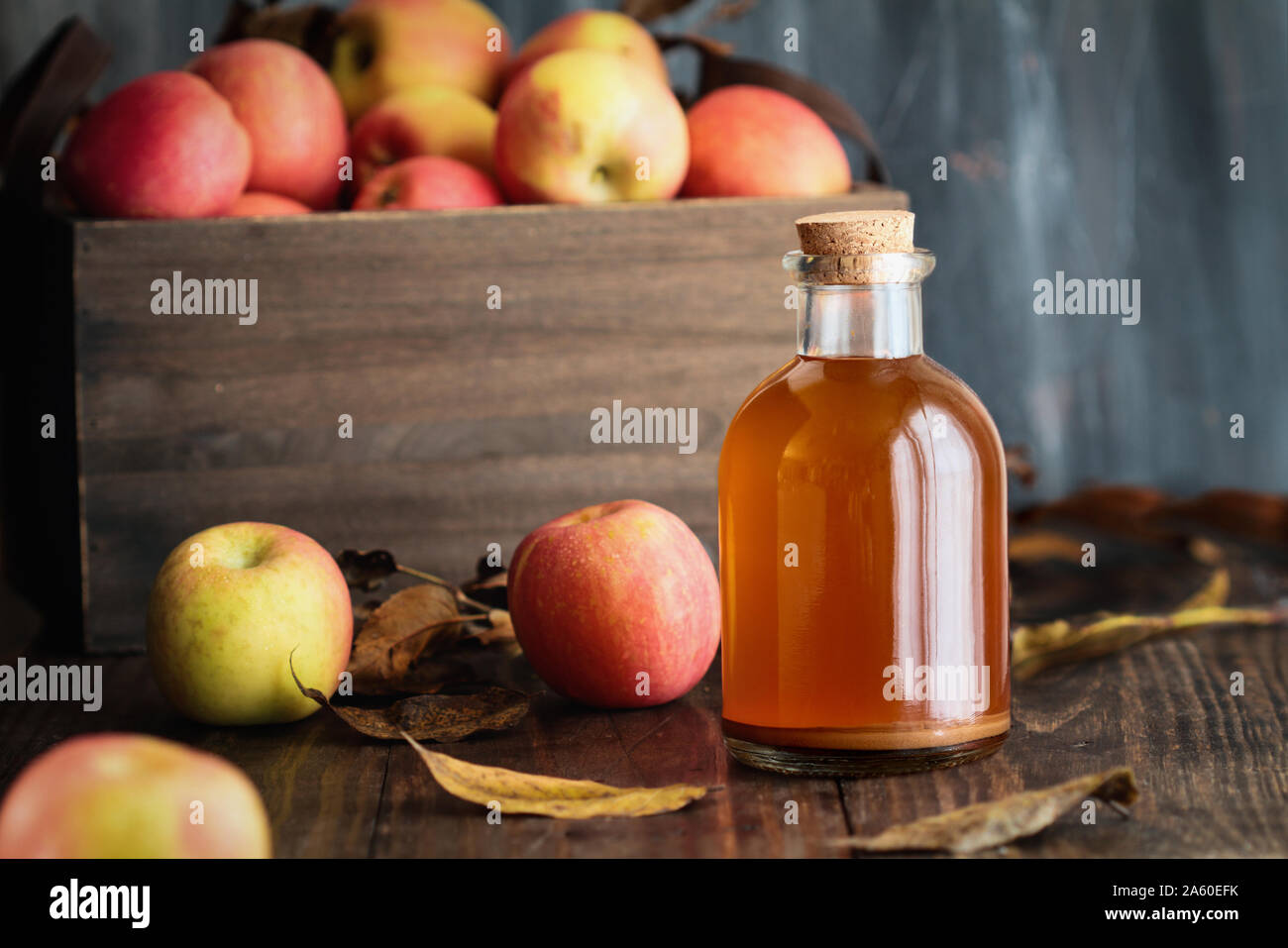 Apple cider vinegar with the mother, yeast and healthy bacteria, surrounded by fresh apples. Apple cider vinegar has long been used in naturopathy to Stock Photo