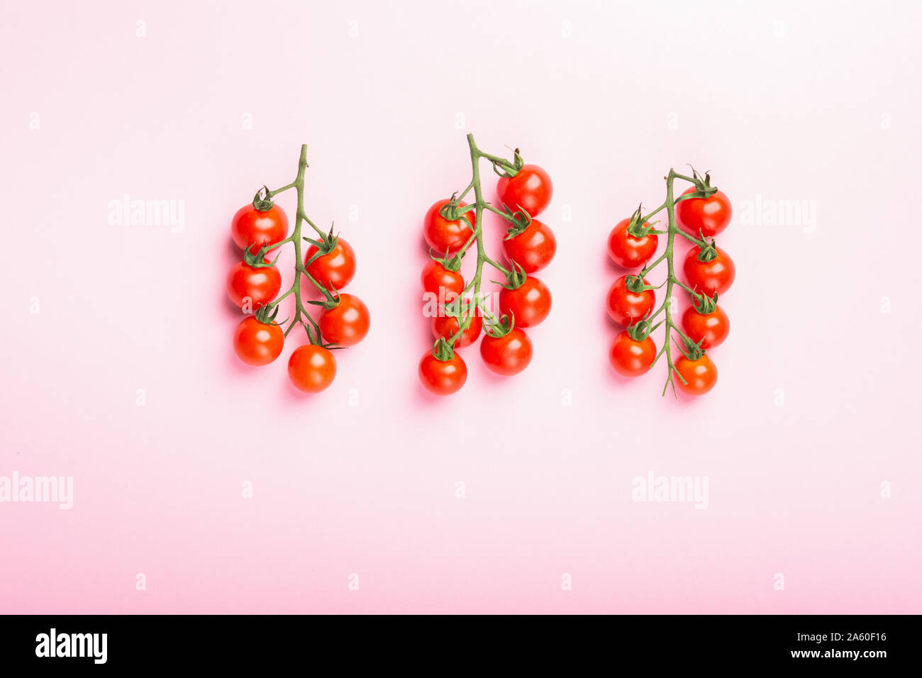 Cherry tomatoes on pink background Stock Photo
