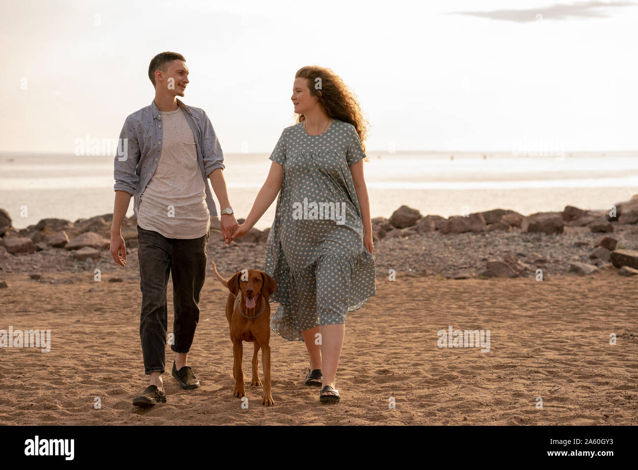 Young couple with dog at the beach Stock Photo - Alamy
