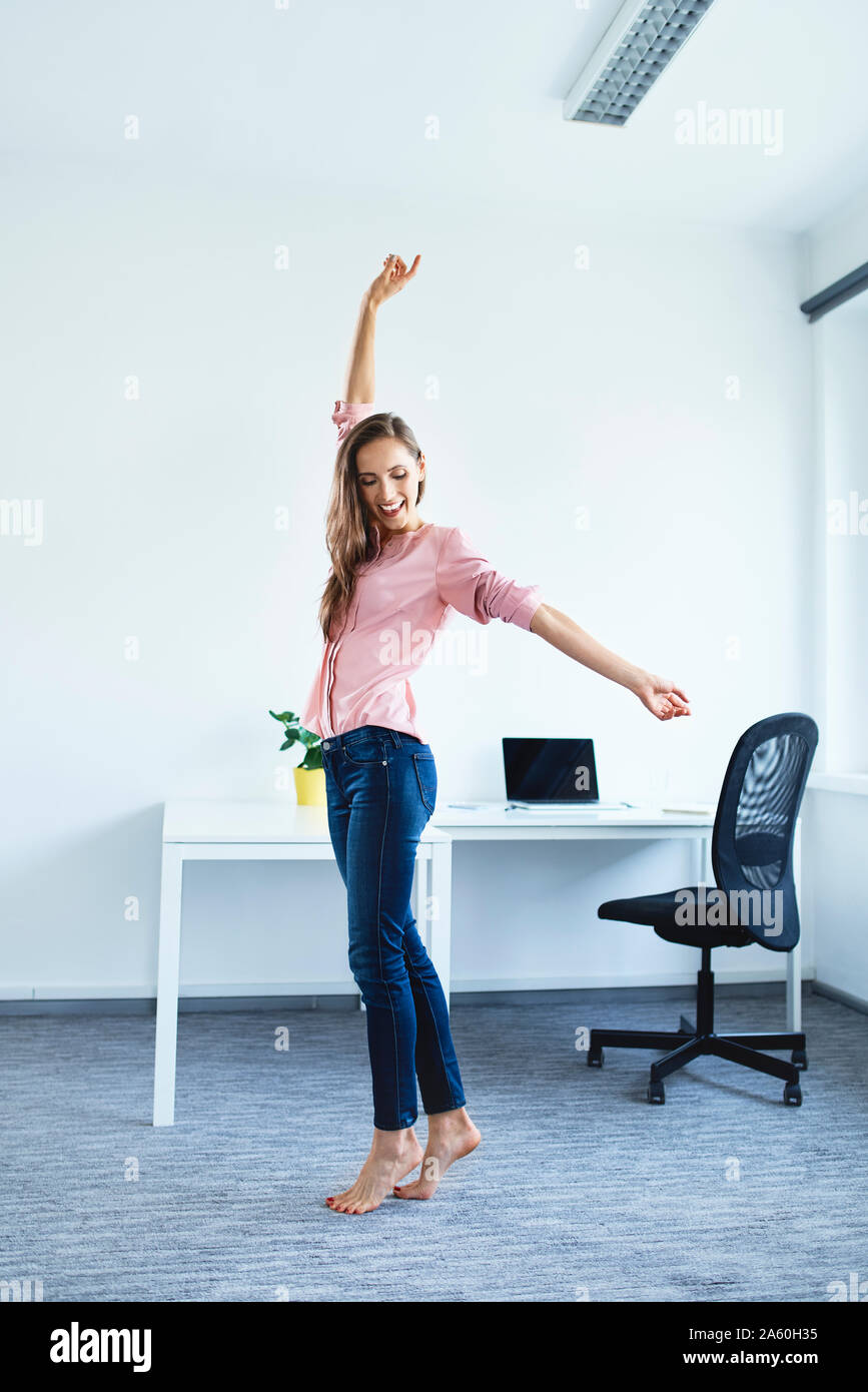Cheerful young woman standing in office Stock Photo