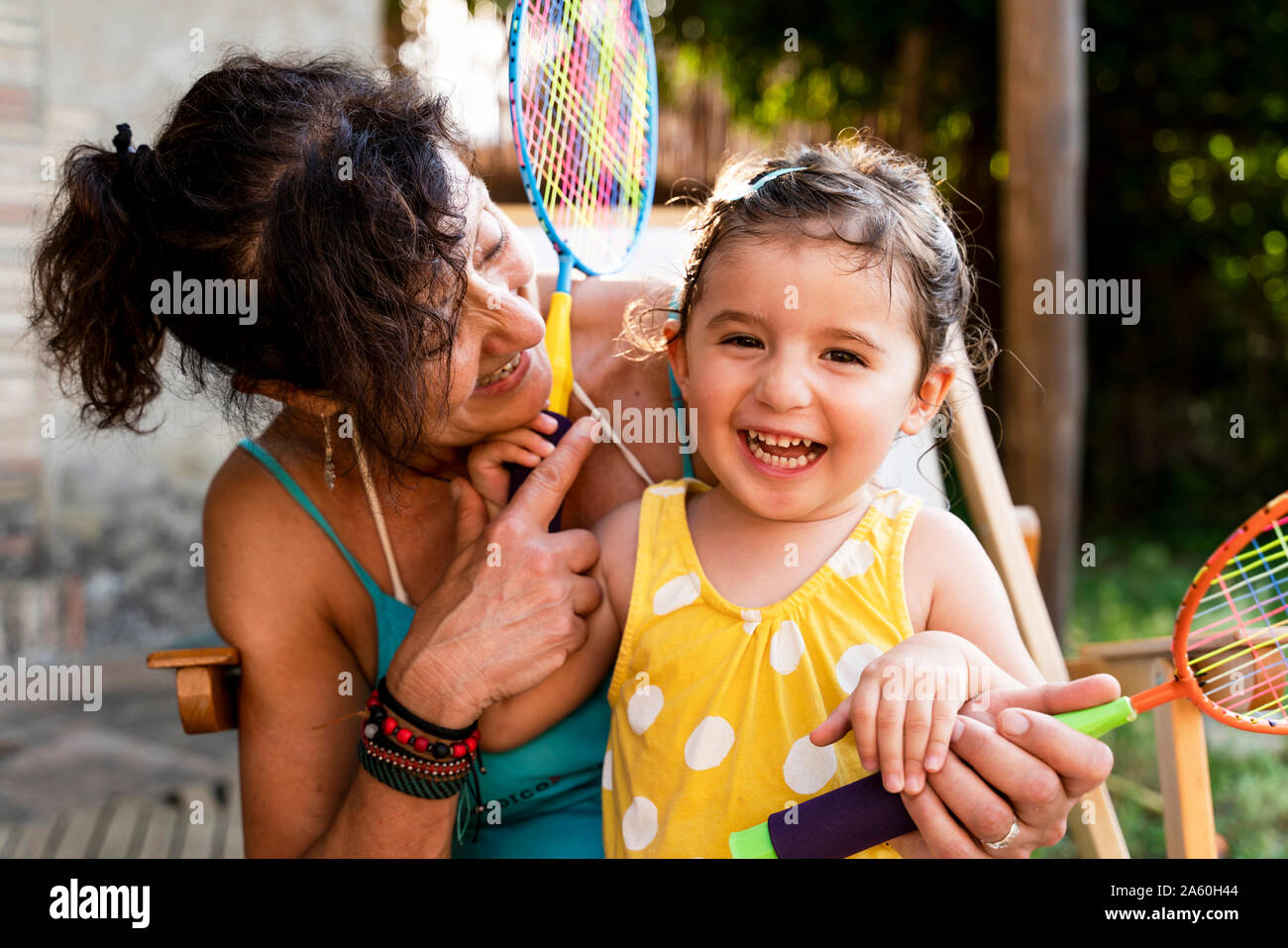 Grandmother playing with little girl and badminton rackets outdoors Stock Photo