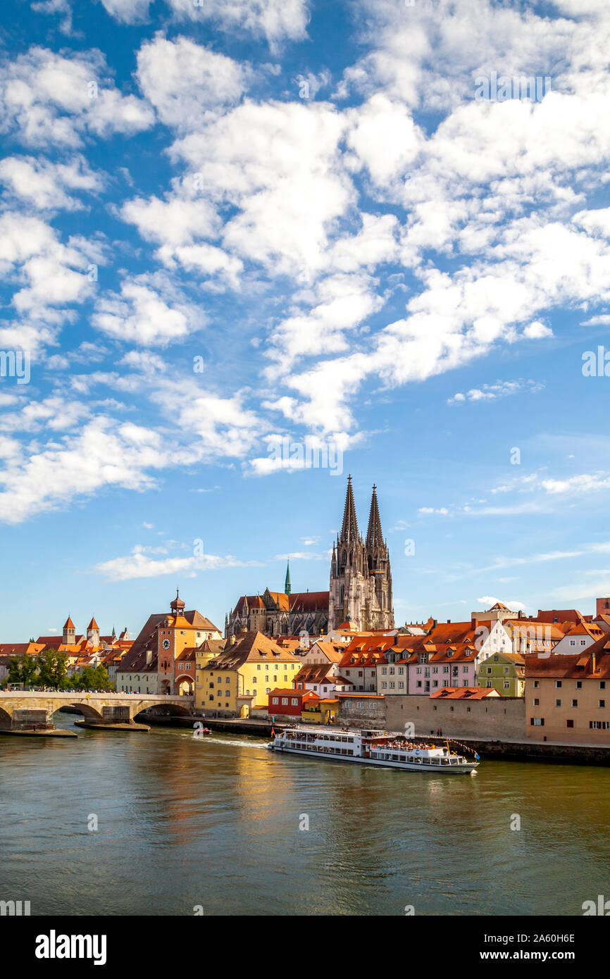 Ferry moving on Danube River by St. Peter's Church in Regensburg, Germany Stock Photo