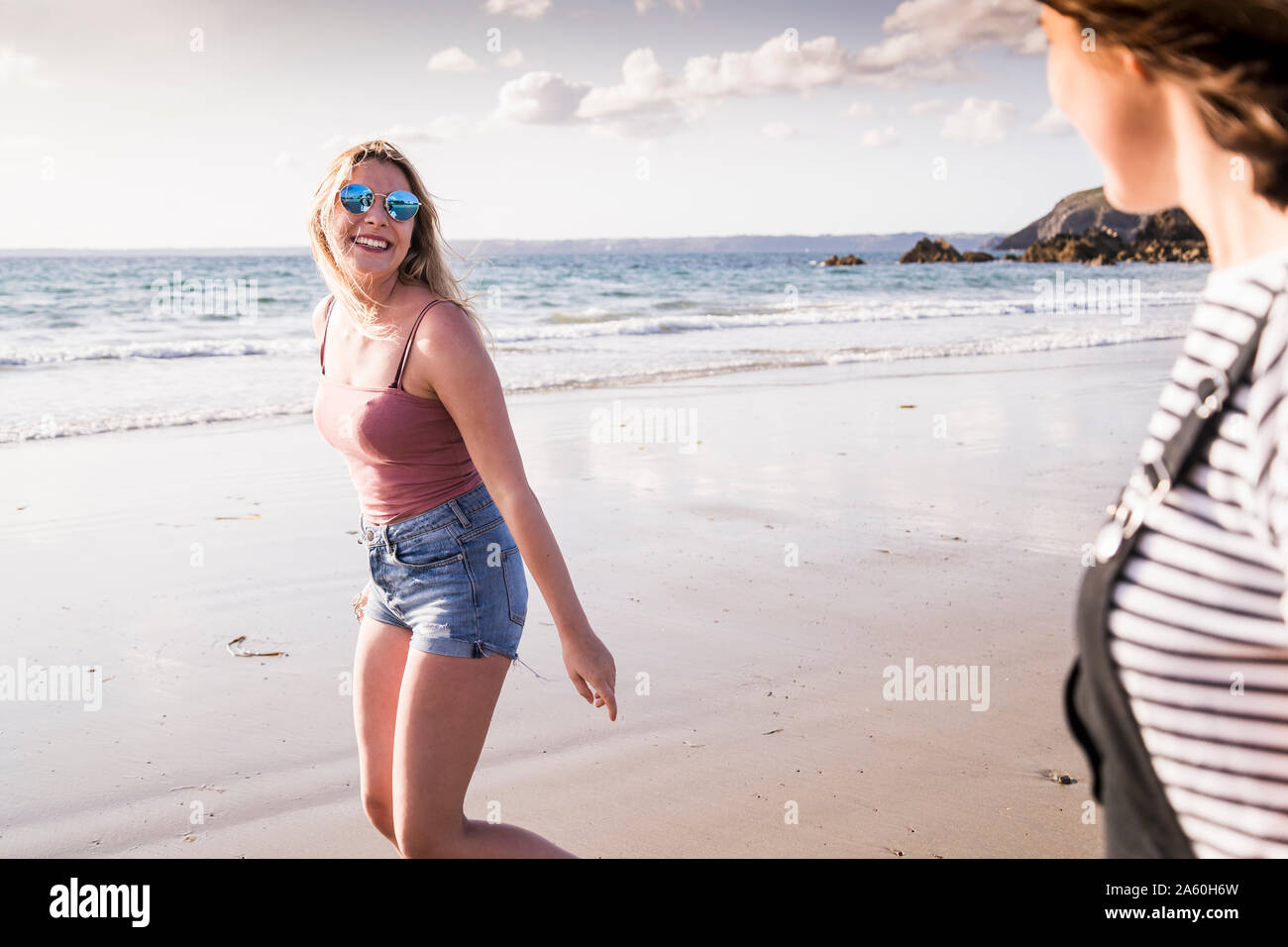 Two girlfriends having fun, walking on the beach Stock Photo