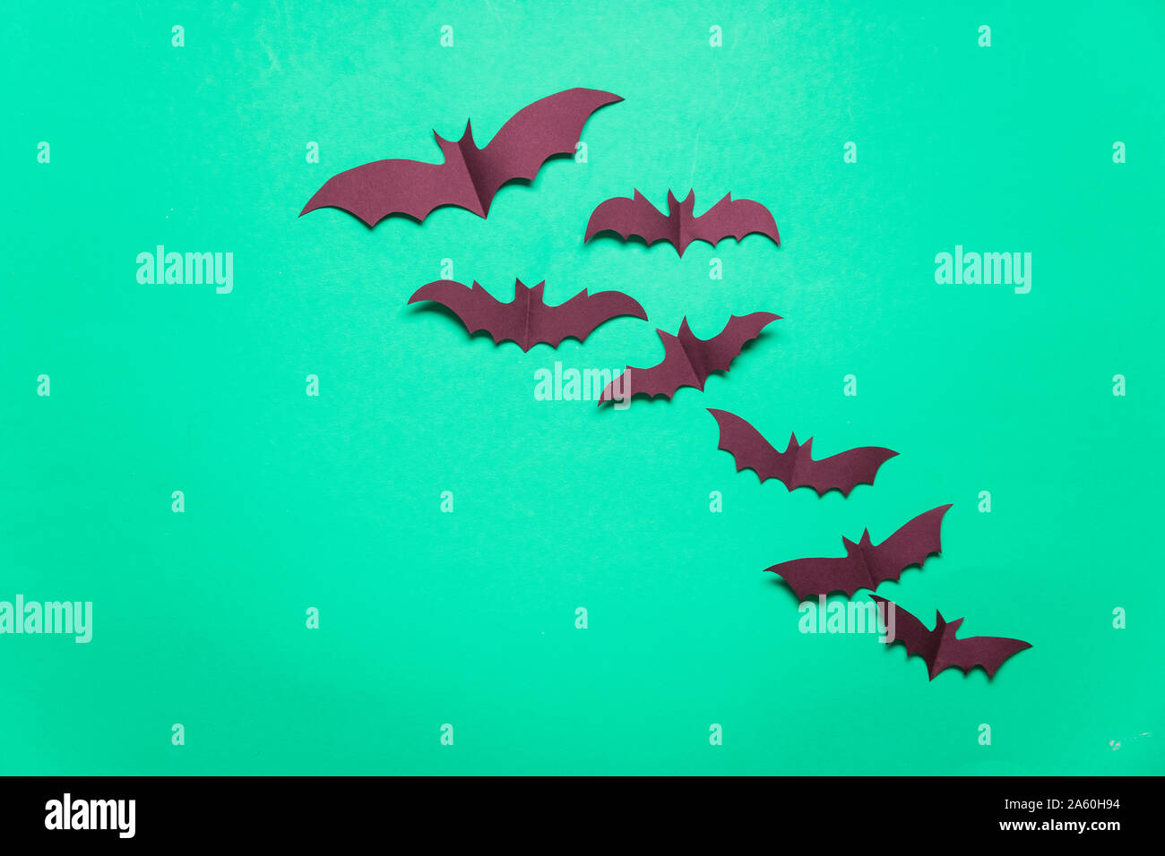 Halloween paper vampire bat decorations on a green background. Stock Photo